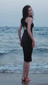 迪丽热巴光着美足踩在海滩上，身着黑裙展露迷人风姿（第3张/共14张）